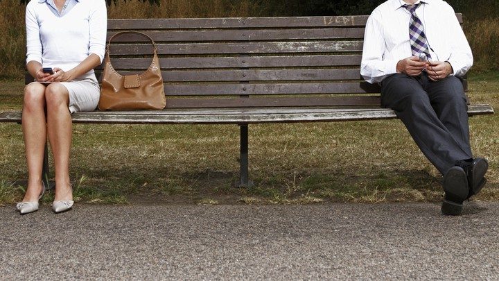 businesswoman-and-businessman-sitting-on-park-bench